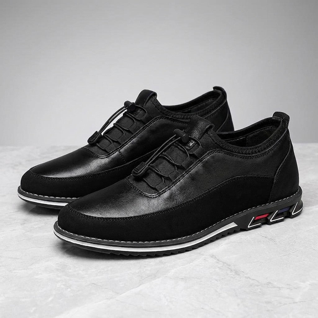 Sutri Leather Slip-On Shoes — Black, pair in three-quarter view on light-grey marble