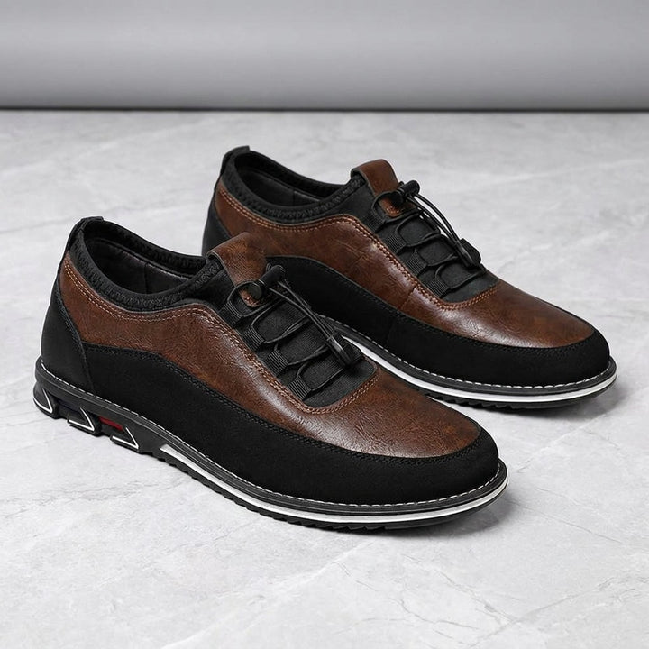 Sutri Leather Slip-On Shoes — Chestnut Brown, pair in three-quarter view on light-grey marble