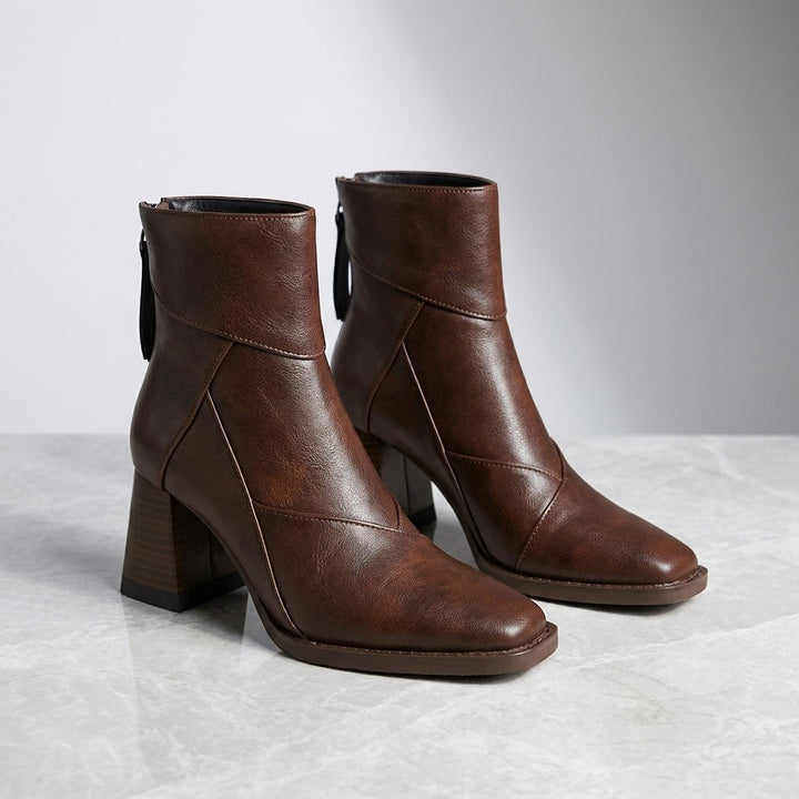 Tropea Paneled Ankle Boots — Brown, pair of boots, three-quarter view on light grey marble