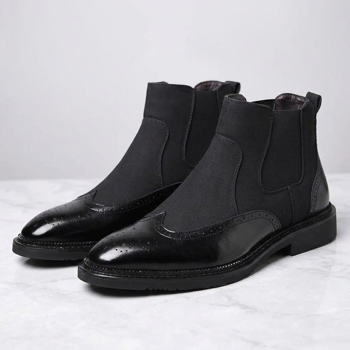 Montefalco Brogue Chelsea Boots — Black, pair of Chelsea boots, three-quarter view on light grey marble