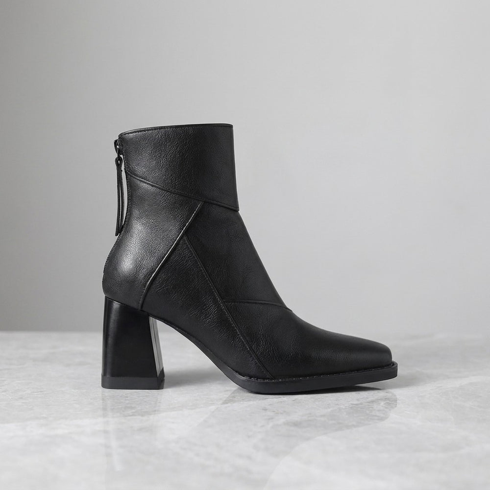 Tropea Paneled Ankle Boots — Black, single boot in side profile on light grey marble