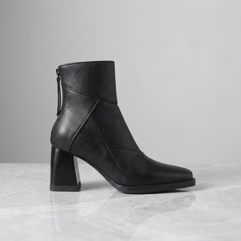 Tropea Paneled Ankle Boots — Black, single boot in side profile on light grey marble
