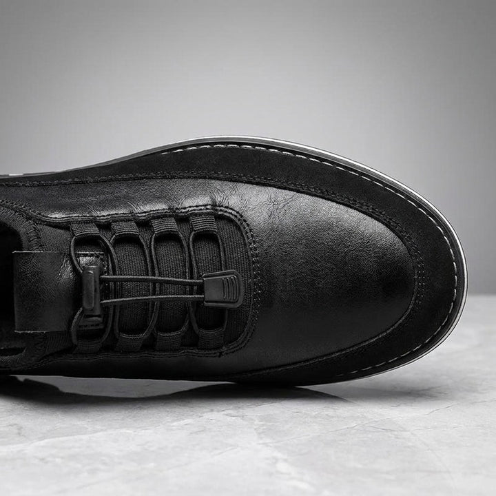 Sutri Leather Slip-On Shoes — Black, close-up of the elastic no-tie laces and stitched upper on light-grey marble