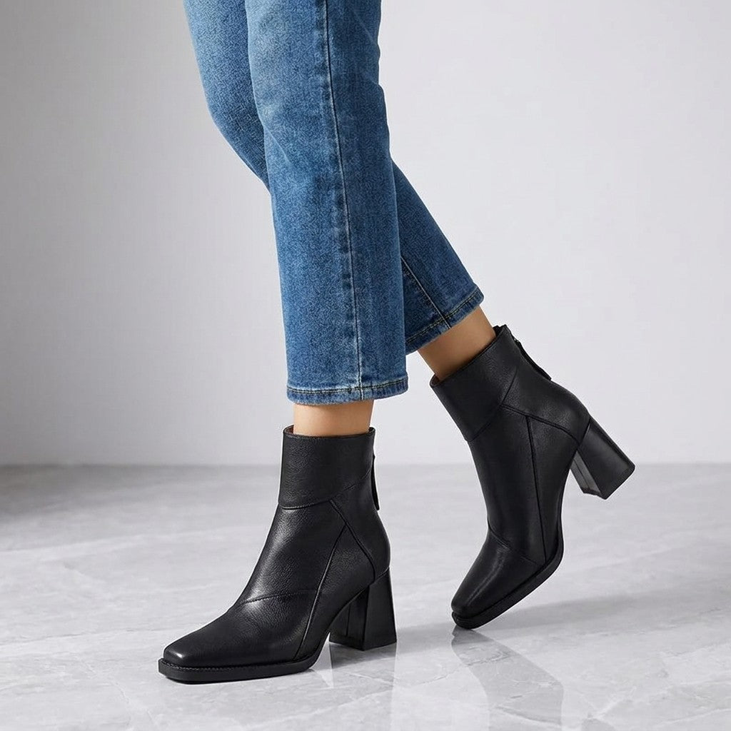 Tropea Paneled Ankle Boots — Black, worn with cropped blue jeans, knee-down on light grey marble