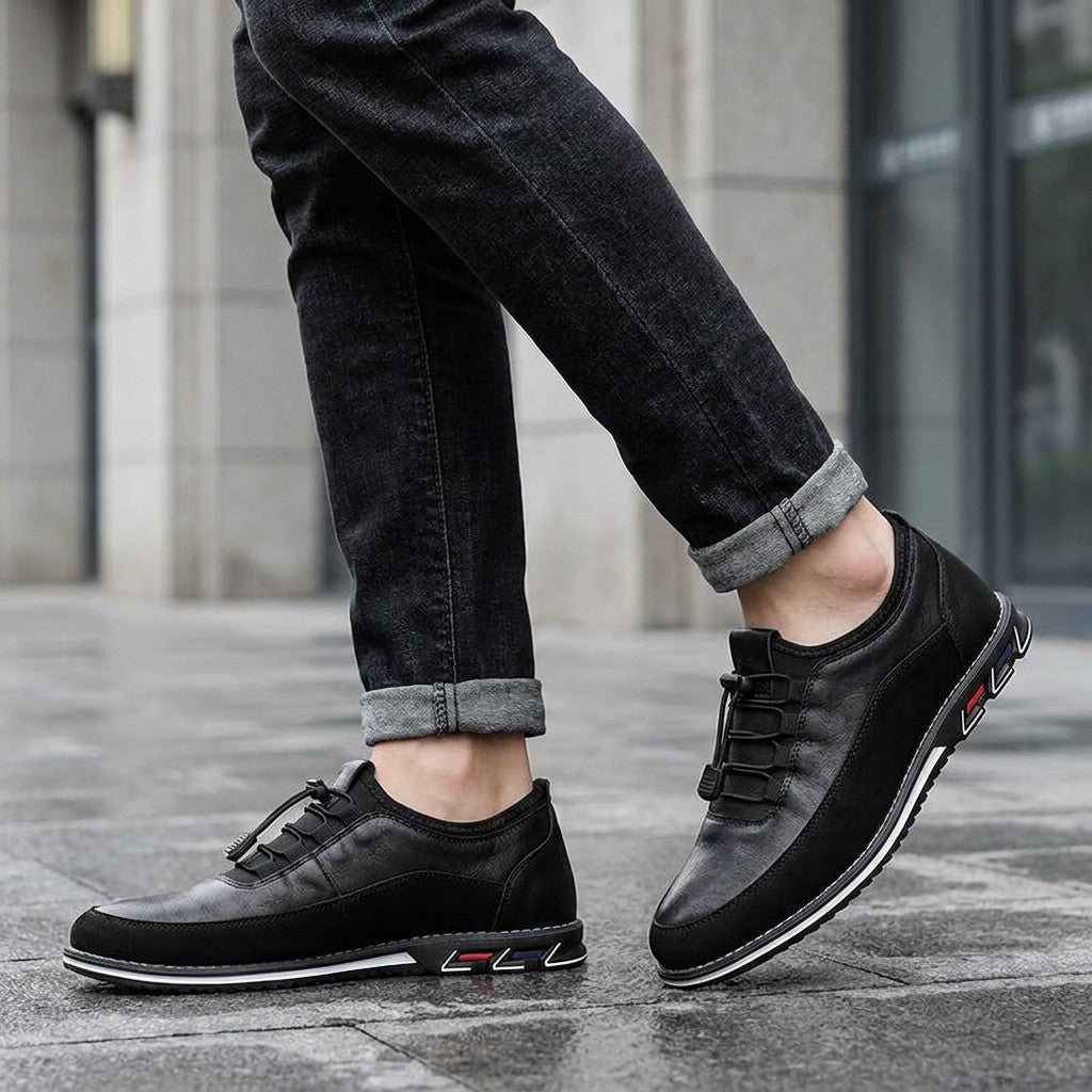 Sutri Leather Slip-On Shoes — Black, worn with dark cuffed jeans on a city sidewalk outside an office building