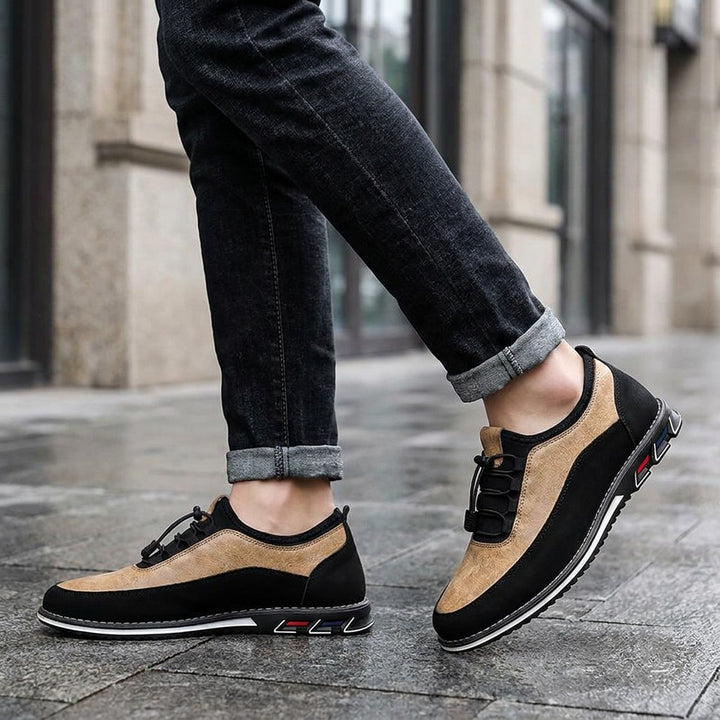 Sutri Leather Slip-On Shoes — Sand, worn with dark cuffed jeans on a city sidewalk outside an office building