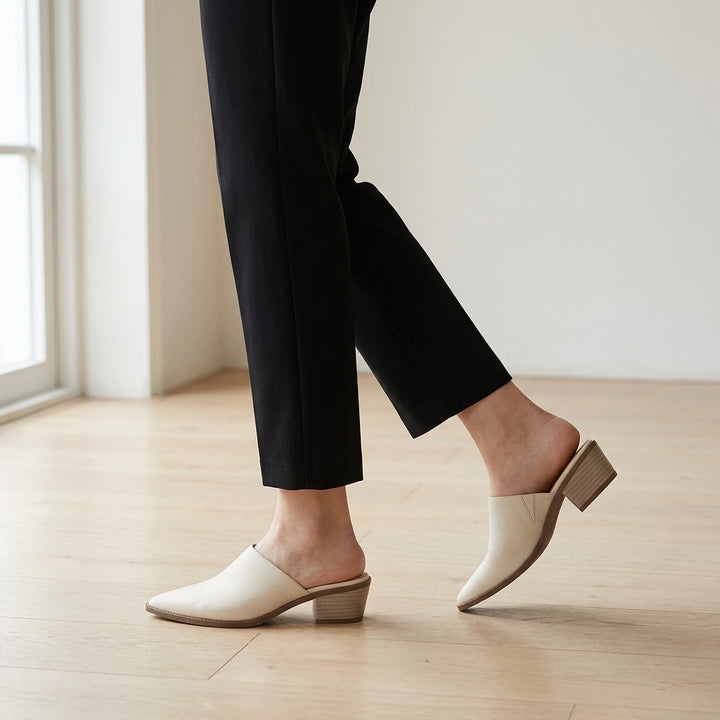 Sabina Leather Mules — Cream, worn mid-stride in a gallery interior