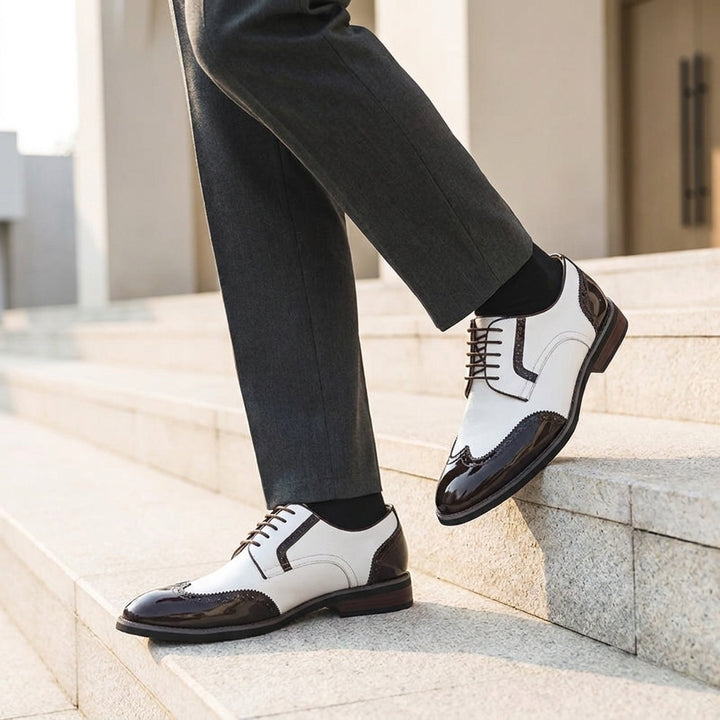 Urbino Leather Wingtip Brogues — White, worn on stone steps