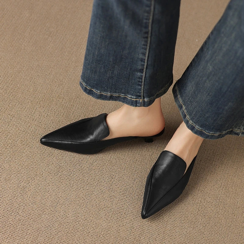 Cervia Leather Mules — Black, worn with blue jeans, side-on view