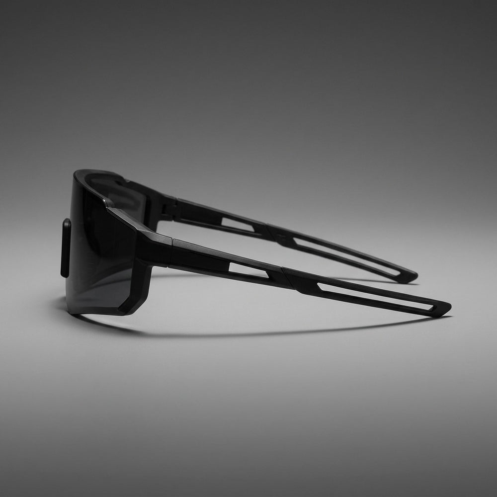 Scilla Shield Sunglasses — Black / Smoke, side profile showing the arm on a grey studio gradient