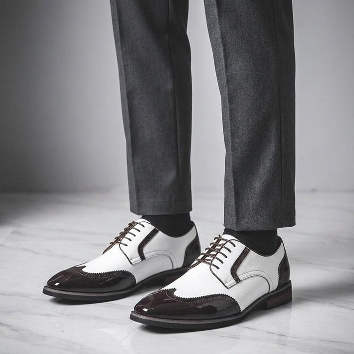 Urbino Leather Wingtip Brogues — White, worn with suit trousers on a marble floor
