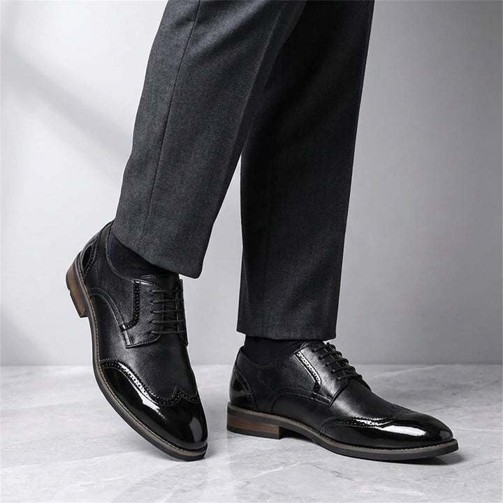 Urbino Leather Wingtip Brogues — Black, worn with suit trousers on a marble floor