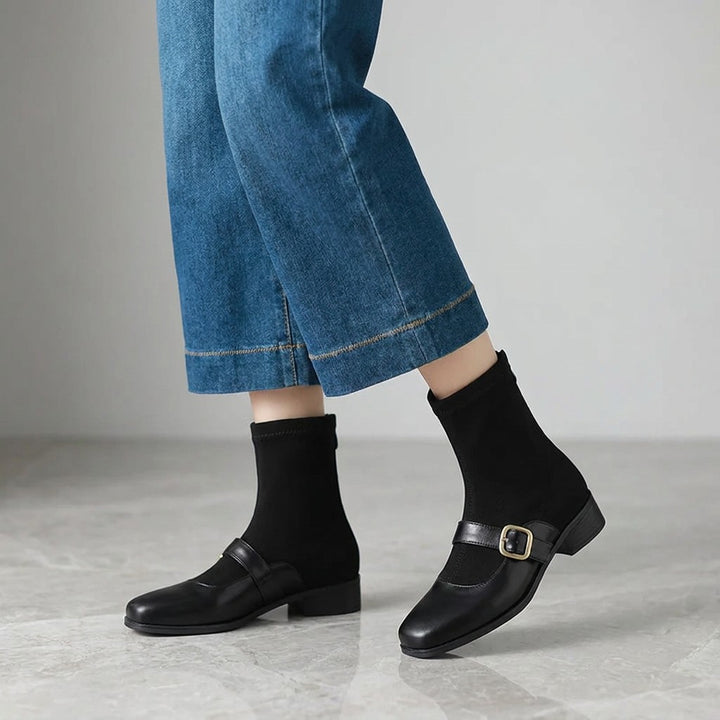Pesaro Mary Jane Ankle Boots — Black, worn by a woman, knee down, on grey marble