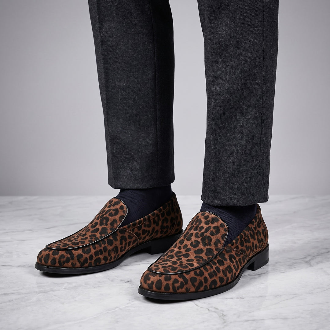 Polignano Leopard Loafers — Brown Leopard, worn by a man in charcoal trousers, knee down, on marble