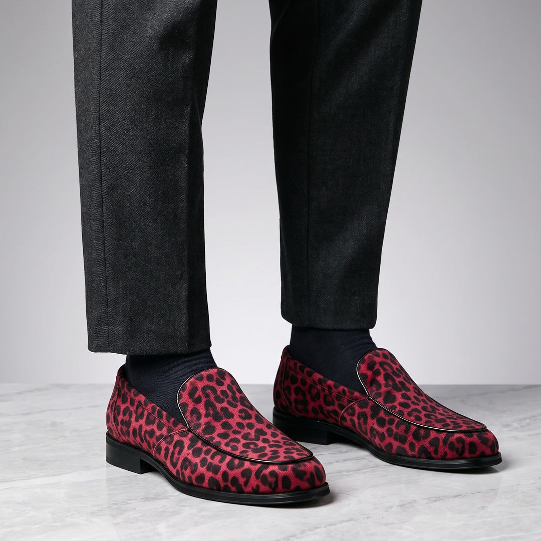 Polignano Leopard Loafers — Red Leopard, worn by a man in charcoal trousers, knee down, on marble