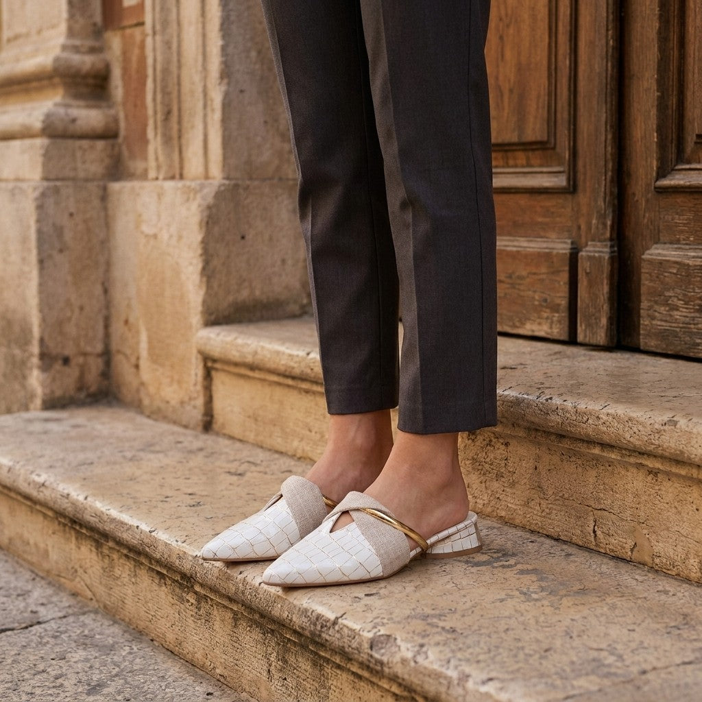Orvieto Croc-Embossed Mules — White, on model at restaurant steps