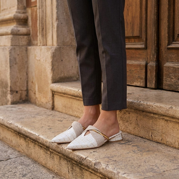 Orvieto Croc-Embossed Mules — White, on model at restaurant steps